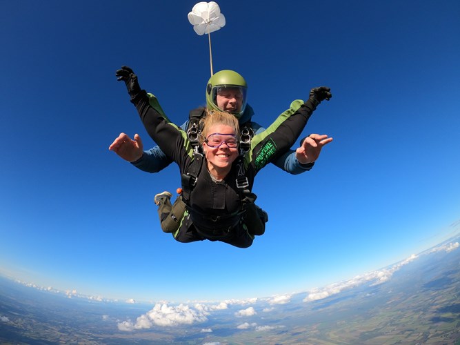 Vrouw springt in tandemsprong met trainer bij Dropzone