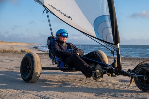 Met de wind in je haren surfen op het strand