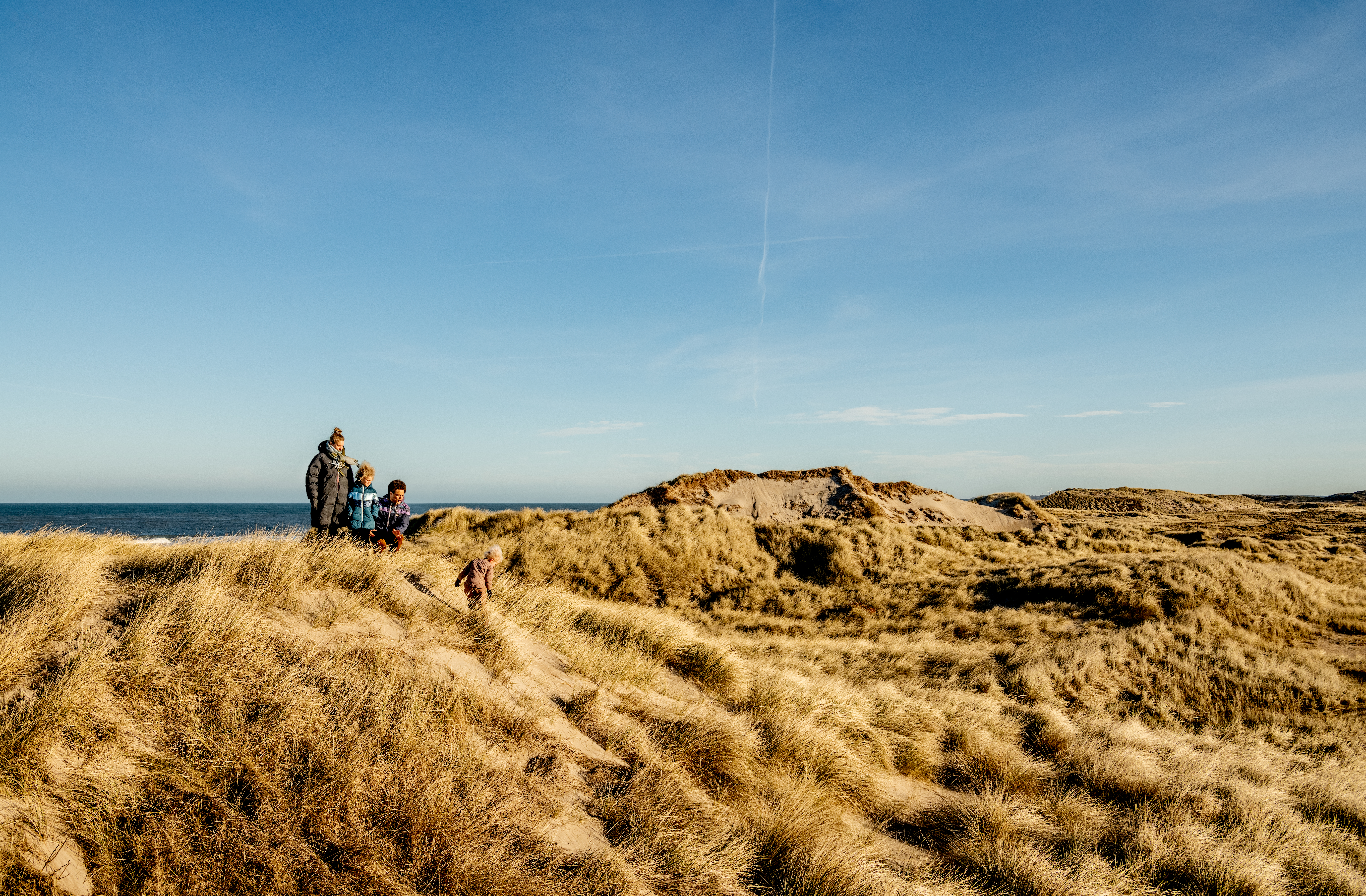 Een gezin in de duinen aan de Noordzeekust © Mette Johnsen