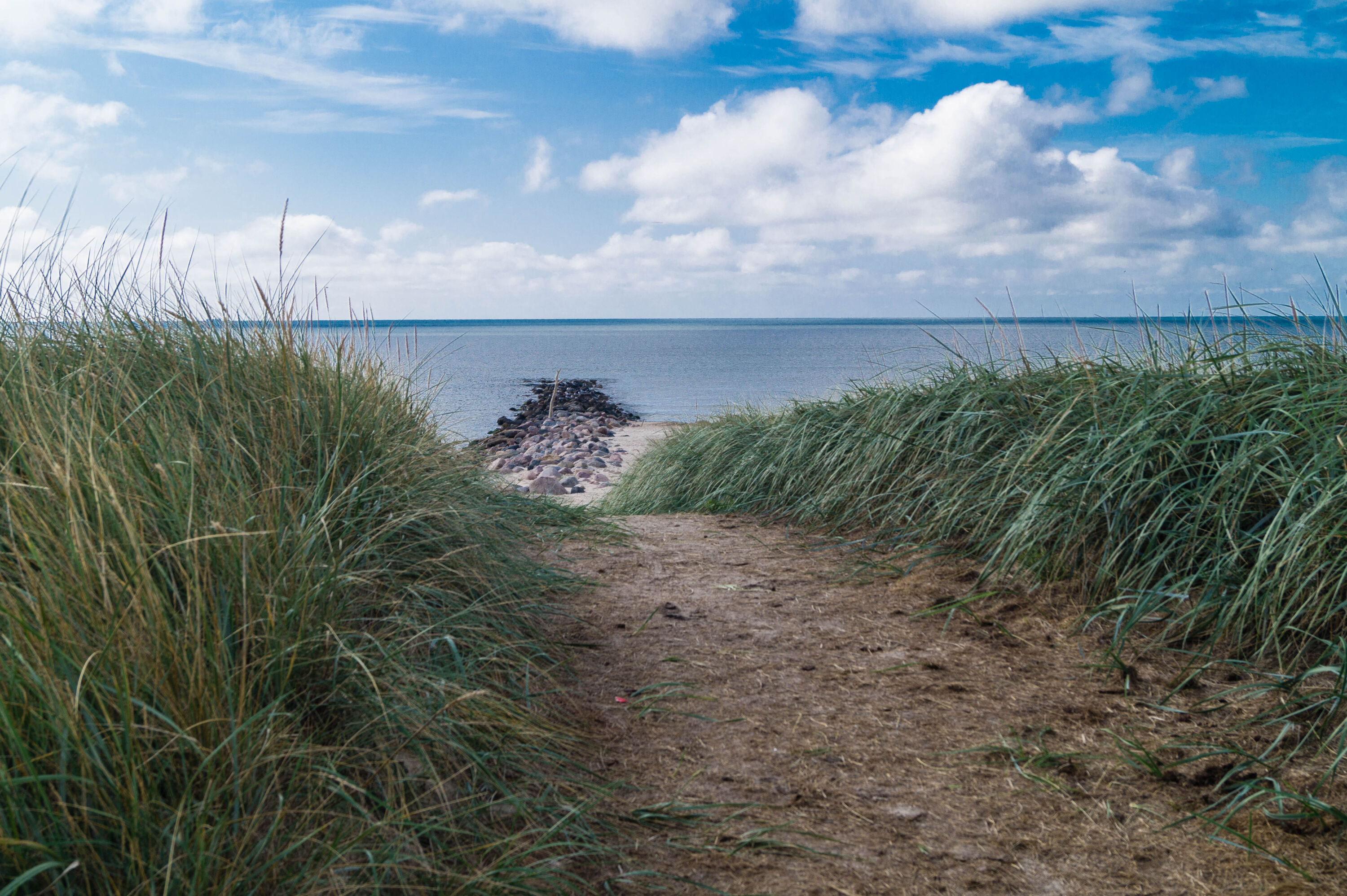 Door de duinen het strand op