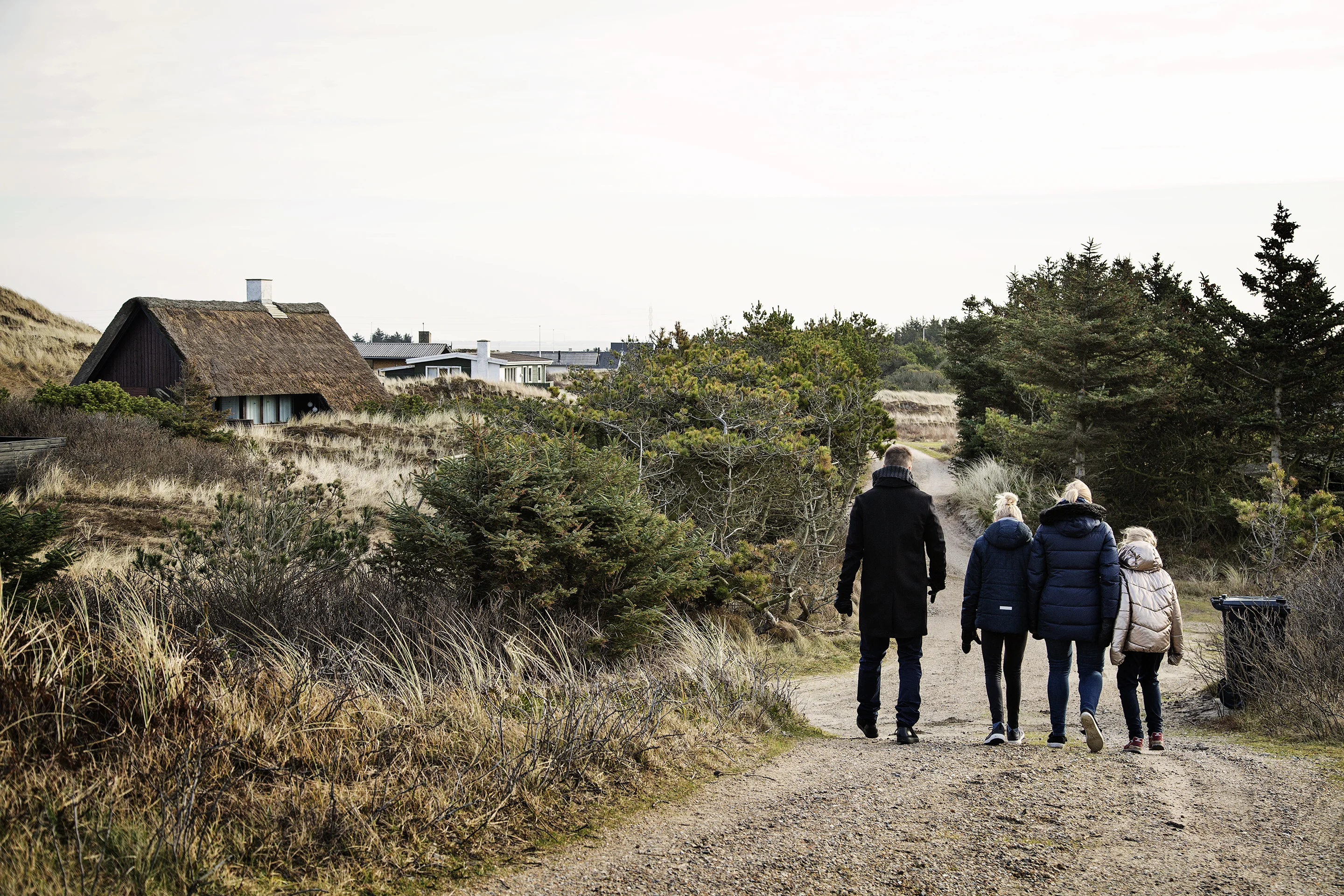 Een familie wandelt in de duinen bij Søndervig